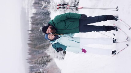 Wall Mural - Vertical footage of mature couple cross country skiing outdoors in winter nature, Tatra mountains Slovakia.