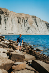 A young man on a rocky beach made of natural stones in the Crimea