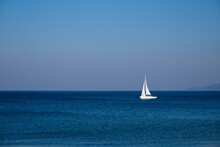 White Sail Boat On Blue Ocean.