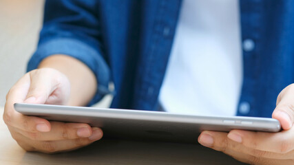 Wall Mural - Close up of man hand using digital tablet for working at home, online study, telecommunication