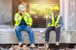 © VStudio - Construction worker, foreman sits and talks with the engineer who supervises the construction site. Construction Workers talking in coffee break in construction site.
