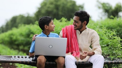 Wall Mural - Education concept :cute indian school boy using laptop and giving some information to his father.