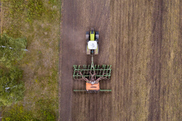 Sticker - Aerial view of agricultural tractor with seeder machine at work on the field	