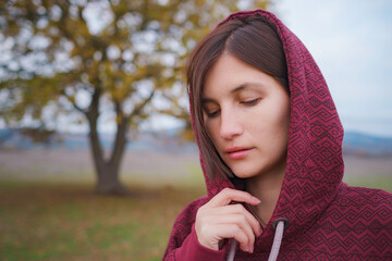 Portrait of a young asian woman in hoodie in the autumn nature. Outdoor atmospheric lifestyle portrait. Season and people