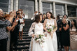 © supamotion - Candid shot of two female lesbian LGBT brides walking down the stairs during their wedding ceremony, guest clapping and cheering