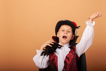 Wall Mural - American-looking boy with a spider in his hands dressed as Count Dracula vampire