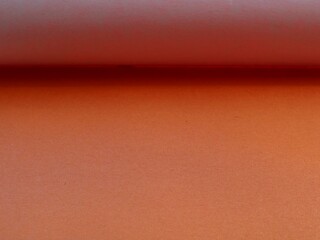 Wall Mural - pale orange colored paper as a texture graphic resource with lines and shadows in structure, peach paper background with space for text, brownish material as a blank backdrop