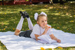 Cute little schoolgirl doing homework in a sunny autumn park. Outdoor education for children. Back to school concept