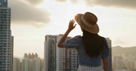 Wall Mural - Woman look at the city in beautiful sunset