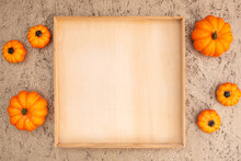 Colorful Decorative Pumpkins And Empty Crate On Plywood Background Upper View Space For Design. Autumn Holiday Celebration