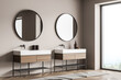 Corner view of bathroom wall with two round mirrors over two vanities