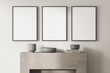 © ImageFlow - Three empty canvases on beige wall with modern living room fireplace