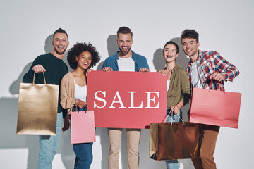 Sticker - Group of young beautiful people in casual clothing carrying shopping bags and smiling