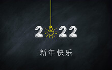 新年快乐  2022. Happy New Year In Chinese (simplified) Idiom On Chalkboard. Creative Concept. 2022 Light Bulb On Blackboard With China Words .