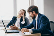 © SHOTPRIME STUDIO - business man and woman sitting at a desk with a laptop communication officials