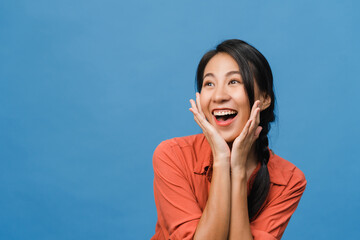 Young Asia lady feel happiness with positive expression, joyful surprise funky, dressed in casual cloth isolated on blue background. Happy adorable glad woman rejoices success. Facial expression.