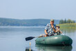 grandfather with grandson together fishing from inflatable boat