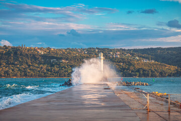 Wall Mural - Lighthouse and splashing wave in Varna, Bulgaria