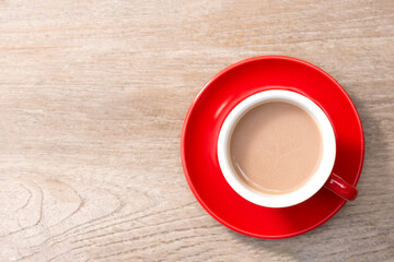 Wall Mural - Red cup of coffee on a wooden table