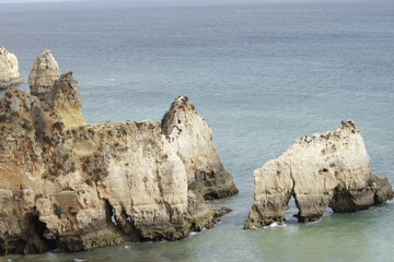 Sticker - Scenic view of rocky cliffs surrounded by the blue ocean