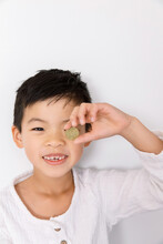 A Happy Young Asian Boy Holding An Australian Coin