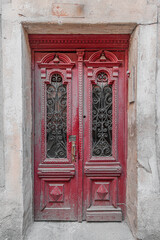 Old closed vintage shabby red wooden door of the 19th century.