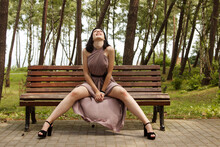 Young Beautiful Woman Sitting On A Park Bench