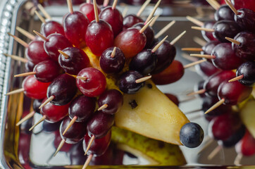 Fruit hedgehog, red grapes and juicy pear, creative way of serving fruit