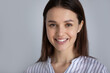 © fizkes - Head shot portrait of smiling young woman with healthy toothy smile and perfect smooth skin on grey background, happy confident successful businesswoman looking at camera, posing for profile picture