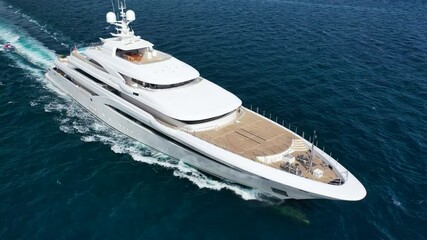 Wall Mural - Aerial drone video of beautiful modern super yacht with wooden deck cruising in high speed deep blue open ocean sea