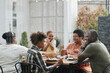 © Seventyfour - Portrait of African-American family enjoying dinner outdoors and smiling while sitting at table together, copy space