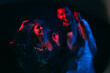 © golubovy - Happy date. Beloved couple. Enjoying celebration. Party joy. Cheerful man and woman dancing together in blue red neon light blur long exposure isolated black.