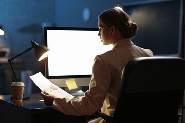 Canvas Print - Young woman working on computer in office late at night