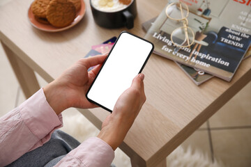 Wall Mural - Woman using mobile phone at home