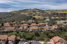 Aerial View Of A Modern Southern California Neighborhood On A Hill With Silky Clouds.