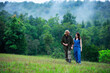 © pixfly - portrait of romantic asian couple embracing while walking in the green field copy space