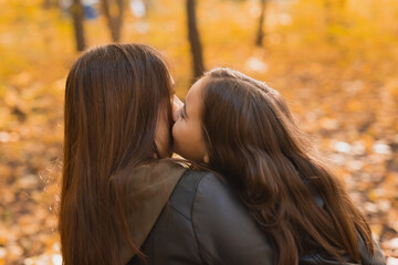 Wall Mural - Mother and daughter spend time together in autumn yellow park. Season and single parent concept.