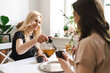 © diignat - Mom, I can share everything with you. Mother and her daughter are sitting in the kitchen having a cup of tea and talking.