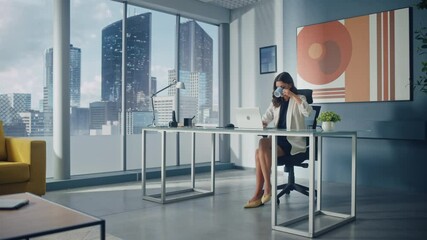 Wall Mural - Portrait of Young Successful Caucasian Businesswoman Sitting at Her Desk Working on Laptop Computer in Big City Office. Confident Corporation CEO Plan Investment Strategy for e-Commerce Startup