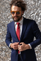 Poster - businessman holding his hands on his button and wearing sunglasses