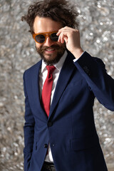 Poster - businessman arranging his sunglasses and smiling at the camera