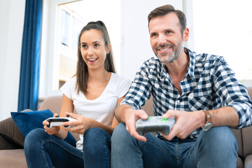 Wall Mural - Couple playing games on console, gamepad in hands