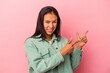 © Asier - Young latin woman isolated on pink background  pointing with forefingers to a copy space, expressing excitement and desire.