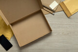 Fototapeta Lawenda - Smart phone, opened empty box,padded mailers,credit card on the wooden table.Free space