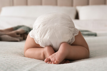 Sticker - Cute little baby in diaper on bed at home