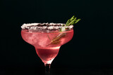 Fototapeta  - Alcoholic or non-alcoholic rosemary cocktail such as margarita, cosmopolitan or similar on a dark marble table