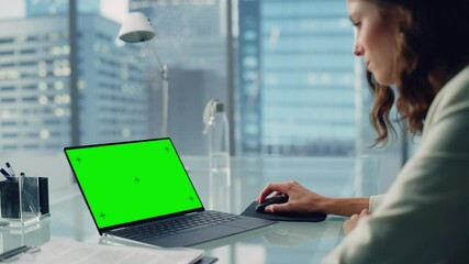 Leinwandbilder - Young Successful Businesswoman Sitting at Desk Working on Green Screen Chroma Key Laptop Computer in City Office. Talented Top Manager Doing Research for e-Commerce Project. Over Shoulder