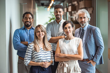 Shot of a group of well-dressed businesspeople standing together. Successful business team smiling teamwork corporate office colleague. Ready to make success happen