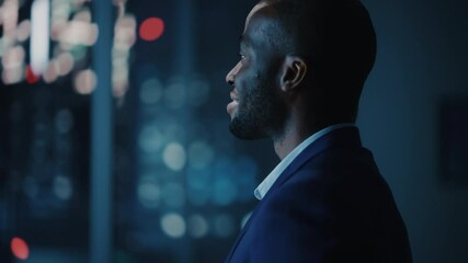 Leinwandbilder - Night Office: Stylish Close-up Portrait of Powerful Black Businessman Wearing Suit Standing, Looking out of the Window on a Big City. Ambitious African CEO Thinking of e-Commerce Investment