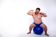 © Denis - Funny fat man training with a fitness ball. Adult guy on a white background. Copy space. Active sports with a diet.